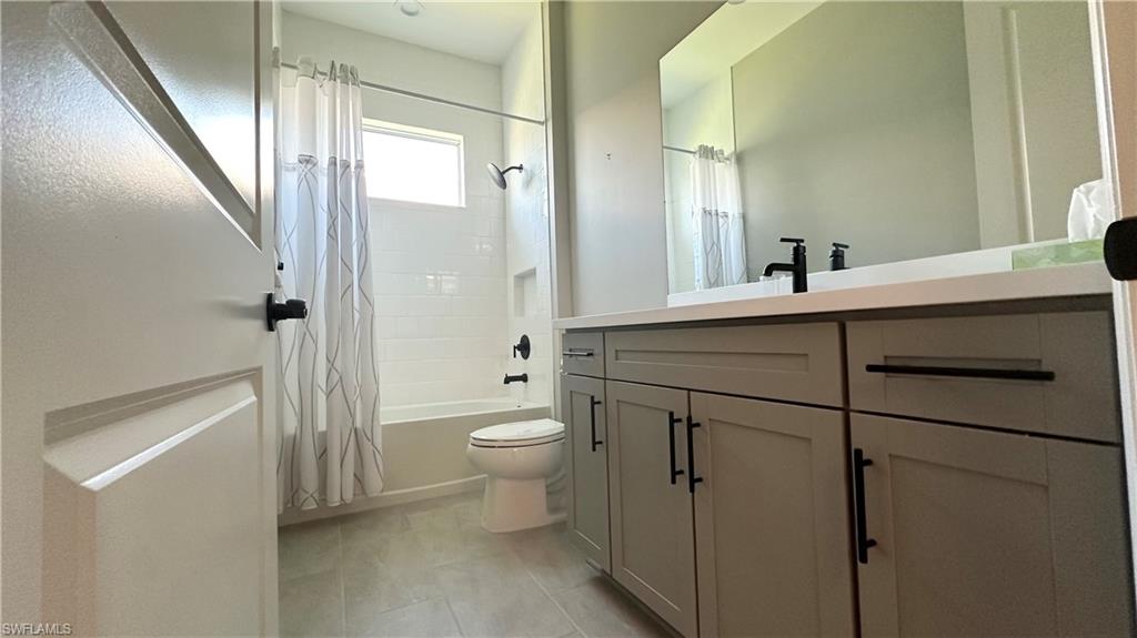 3998 Perseus Street Naples, FL 34120 - Photo 13 of 26 Full bathroom with shower / bathtub combination with curtain and vanity
