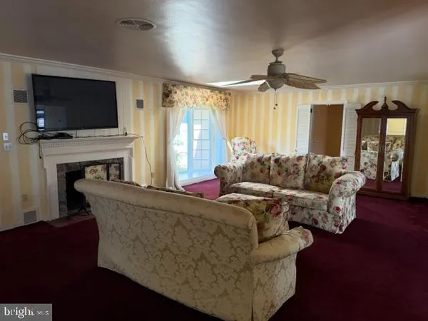 a view of empty room with window and ceiling fan