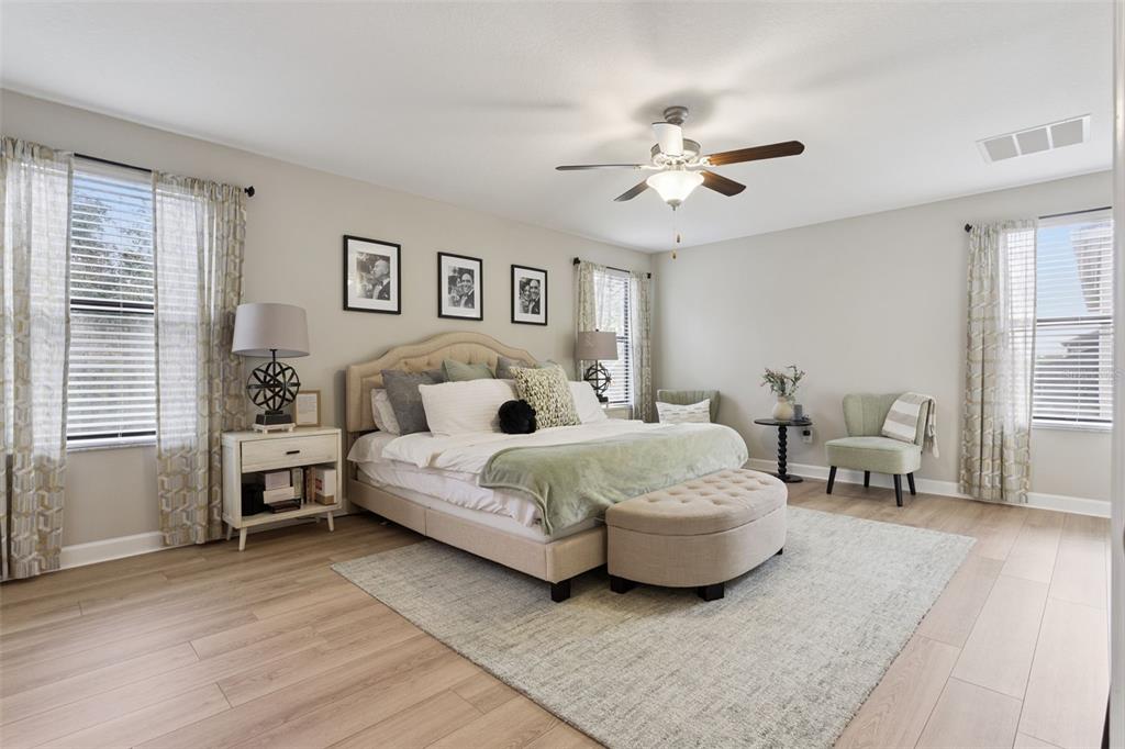 8816 Shady Pavillion Court Land O Lakes, FL 34637 - Photo 22 of 64 a spacious bedroom with a bed and a chandelier