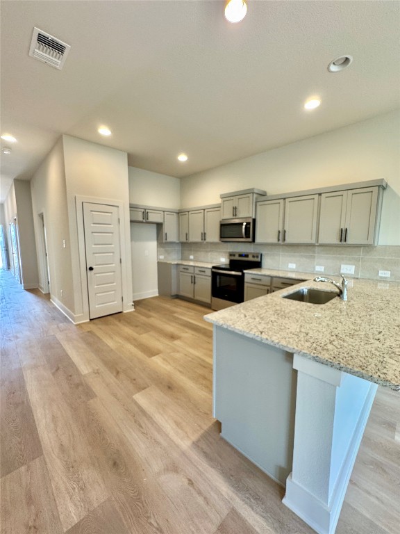 100 Zayd Court, Unit A Jarrell, TX 76537 - Photo 1 of 20 a large kitchen with kitchen island a sink stainless steel appliances and cabinets