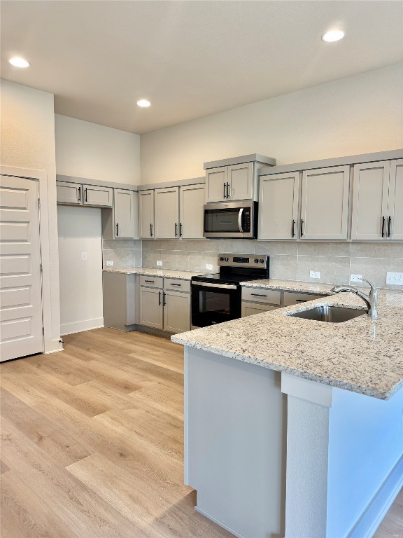 100 Zayd Court, Unit A Jarrell, TX 76537 - Photo 6 of 20 a kitchen with kitchen island granite countertop a sink stove and refrigerator