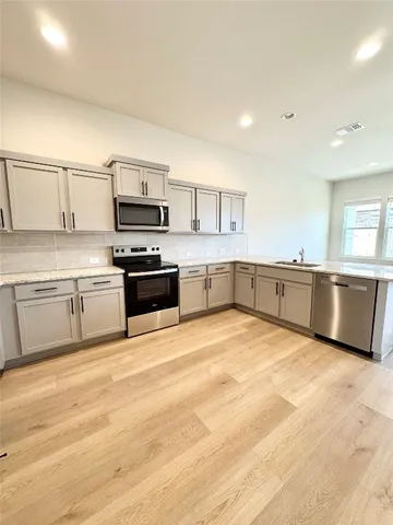 a large kitchen with cabinets and stainless steel appliances