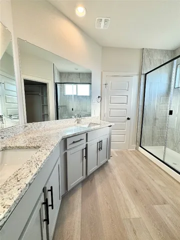 a large kitchen with a stove a sink dishwasher a refrigerator and a oven with wooden floor