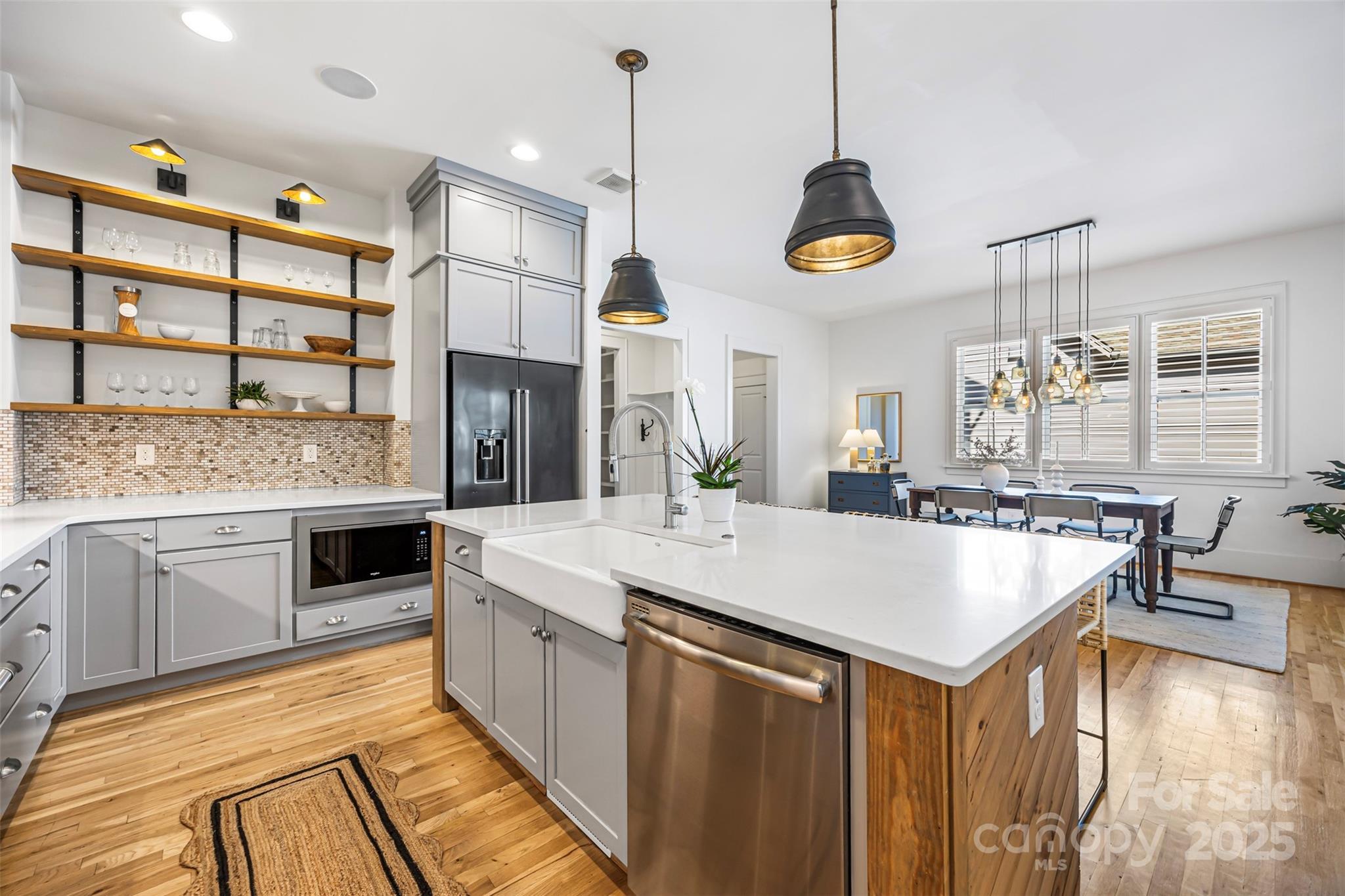 135 Inspired Way Fort Mill, SC 29708 - Photo 16 of 48 a kitchen with stainless steel appliances granite countertop a stove a sink a oven a dining table and chairs with wooden floor