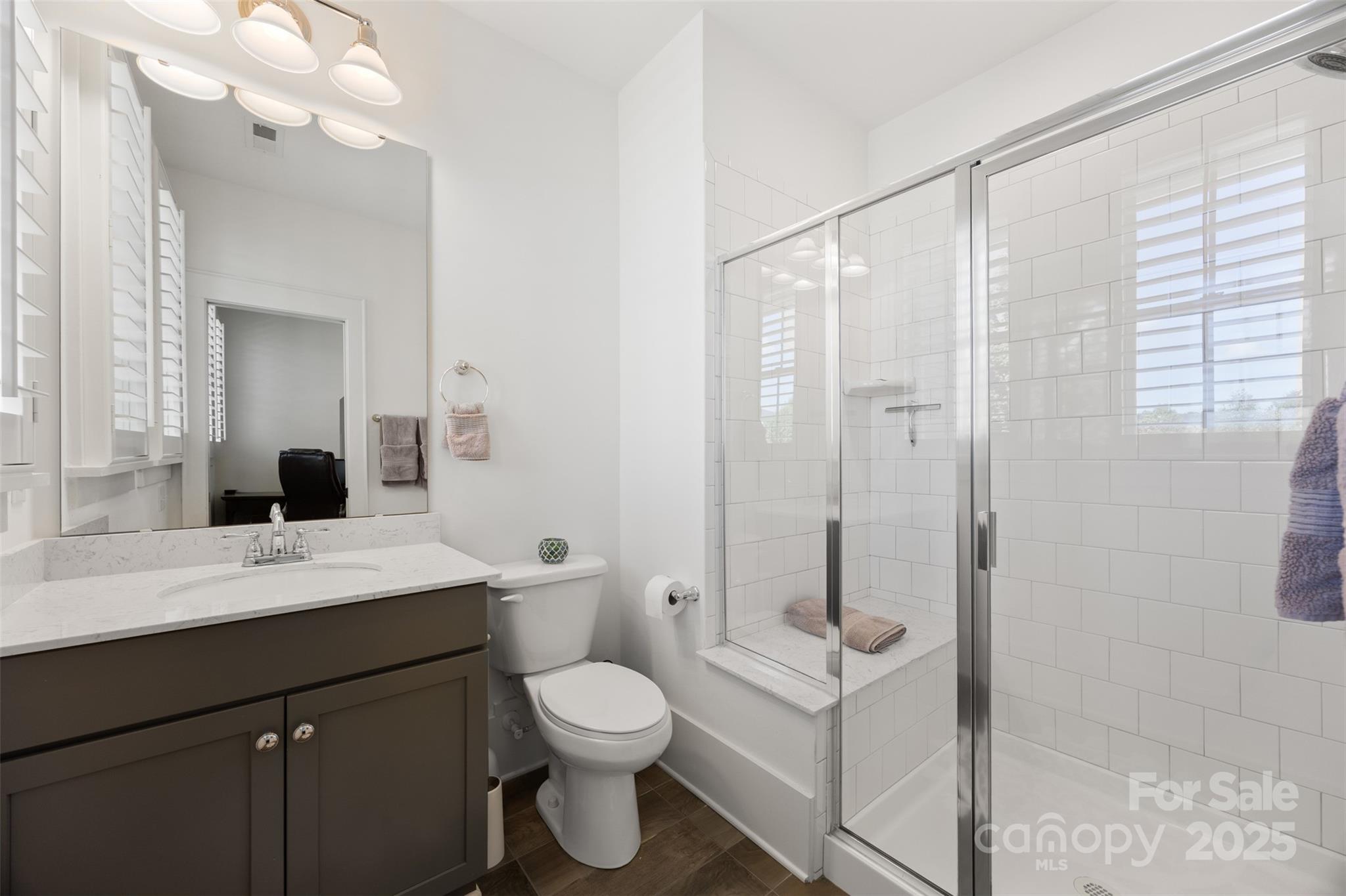 135 Inspired Way Fort Mill, SC 29708 - Photo 31 of 48 a bathroom with a toilet a sink a glass door a shower and a mirror