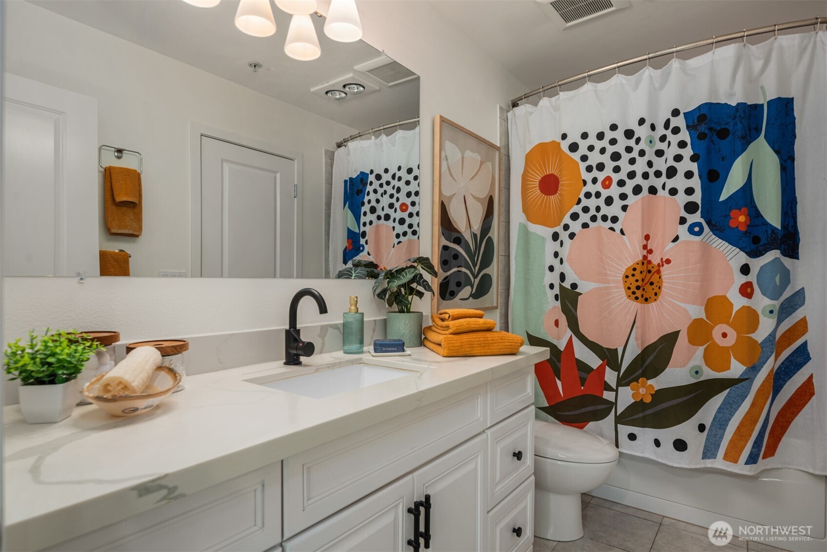 3302 West Government Way, Unit A Seattle, WA 98199 - Photo 21 of 32 a bathroom with a sink and mirror with toilet