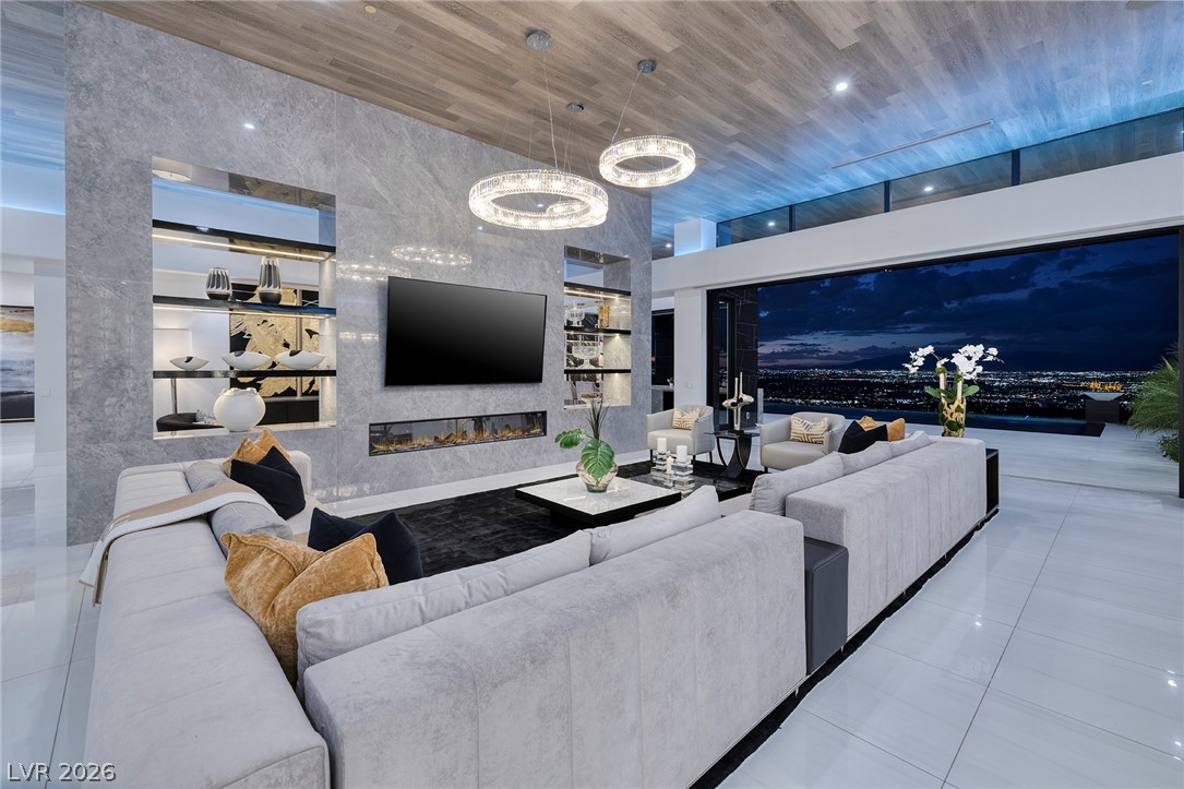 611 Cityview Ridge Drive Henderson, NV 89012 - Photo 9 of 66 Retracting glass walls merge the refined living area with a dramatic evening skyline panorama.