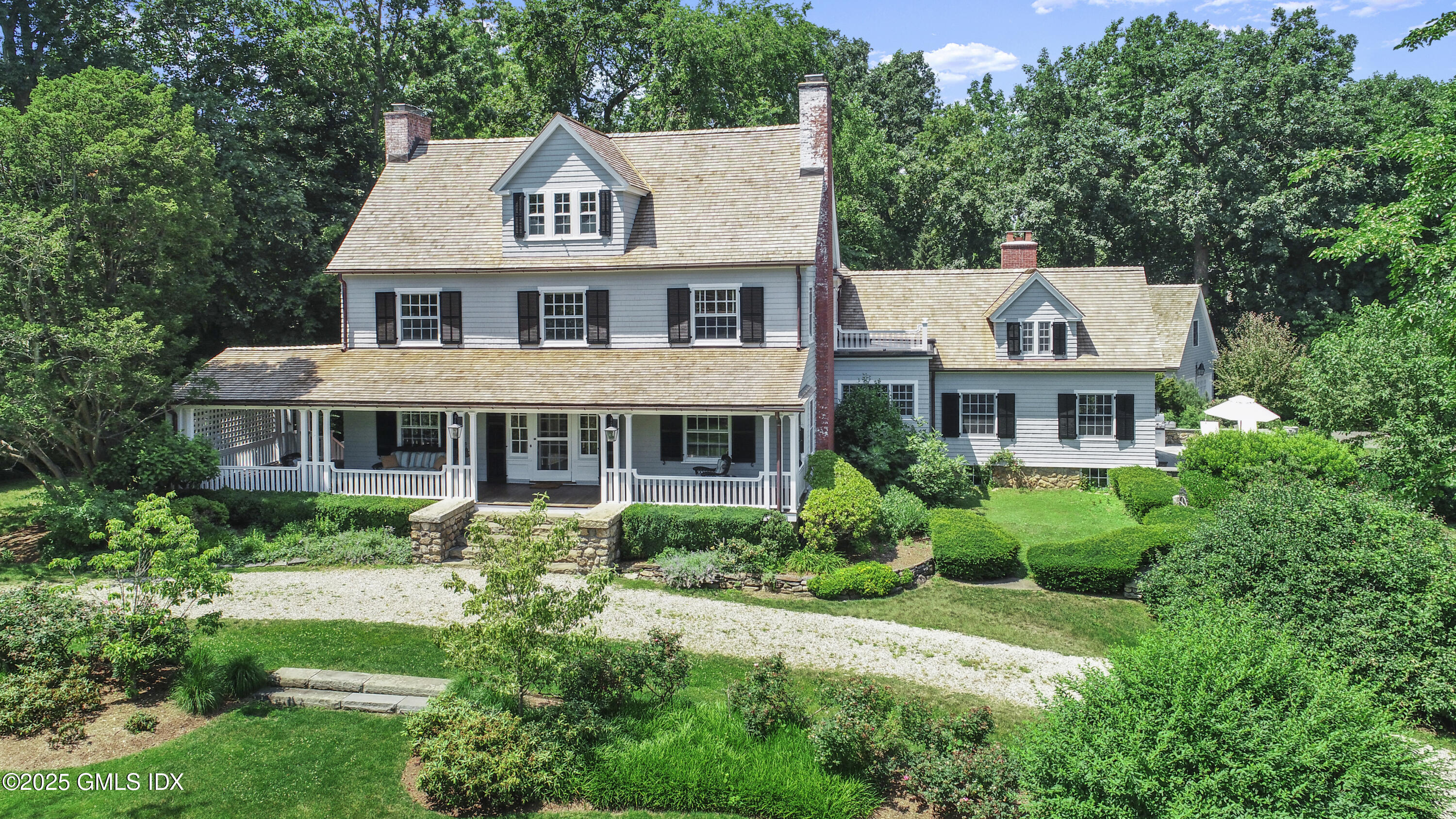 a aerial view of a house next to a big yard and large trees