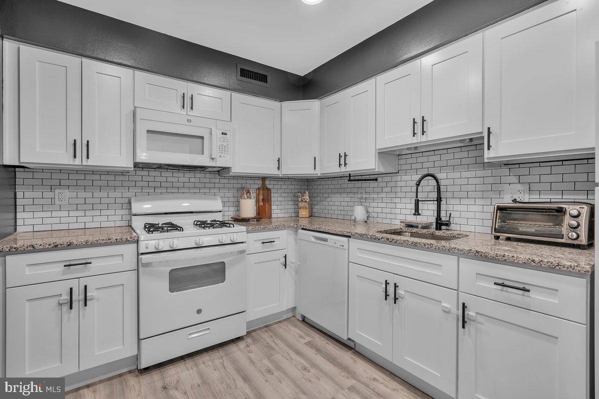 46202 Delaire Landing Road, Unit 202 Philadelphia, PA 19114 - Photo 11 of 34 a kitchen with white cabinets stainless steel appliances and sink