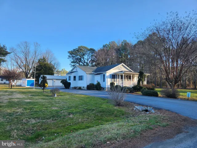 a front view of a house with a yard and trees