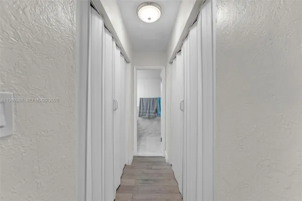 a view of a hallway with wooden floor and staircase