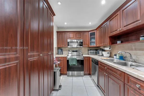 a kitchen with stainless steel appliances granite countertop wooden cabinets a stove top oven a sink and dishwasher