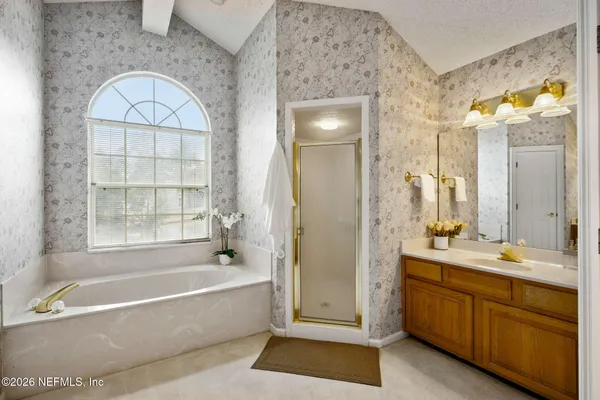 a spacious bathroom with a tub a double vanity sink and a mirror