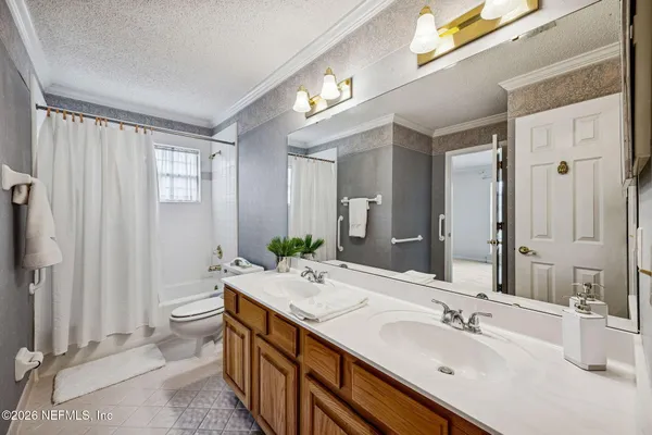 a bathroom with a double vanity sink toilet and shower