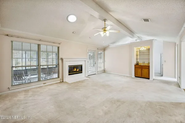 a view of an empty room with a fireplace and a window