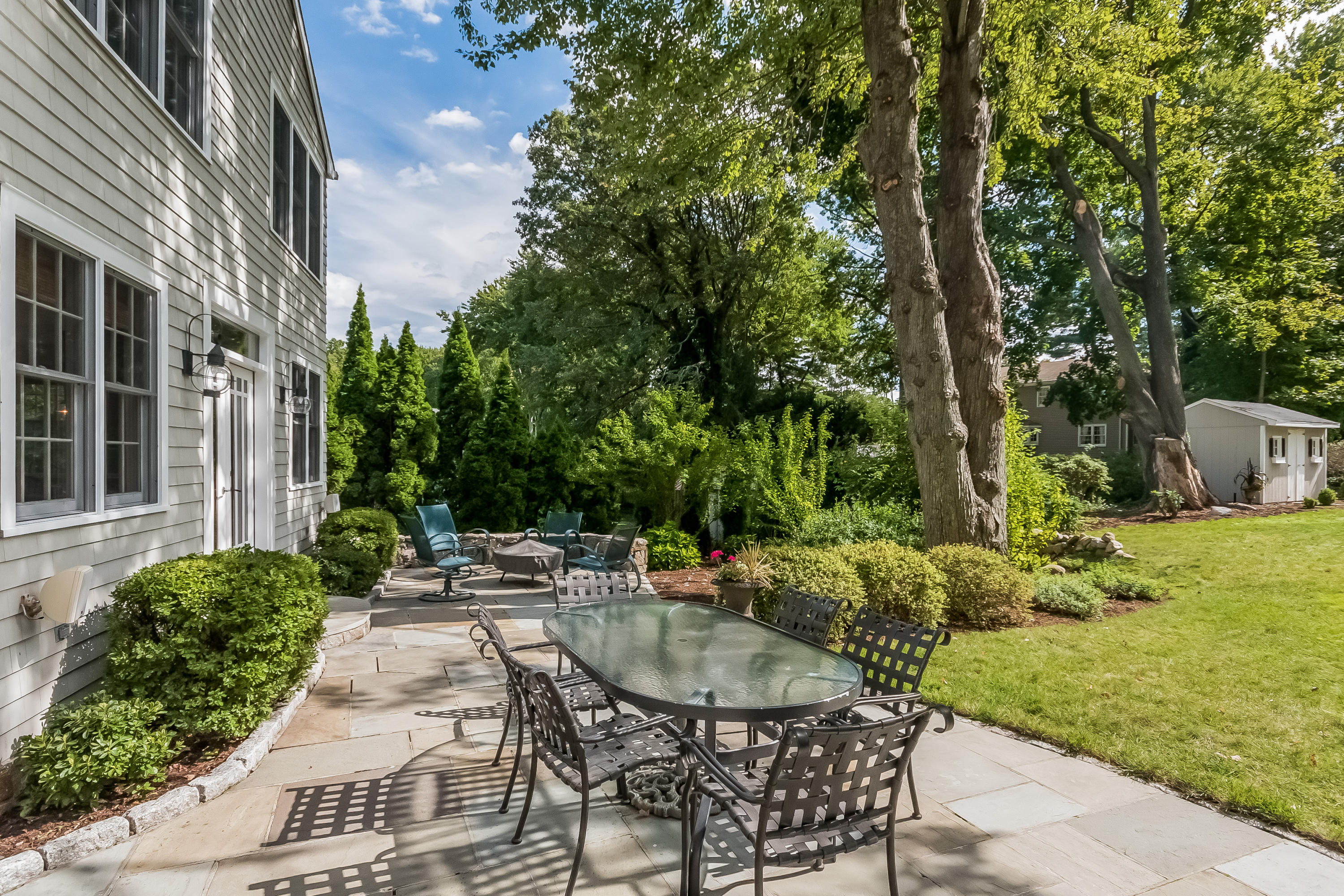8 Laforge Road Darien, CT 06820 - Photo 3 of 34 a view of a patio with table and chairs potted plants and large tree