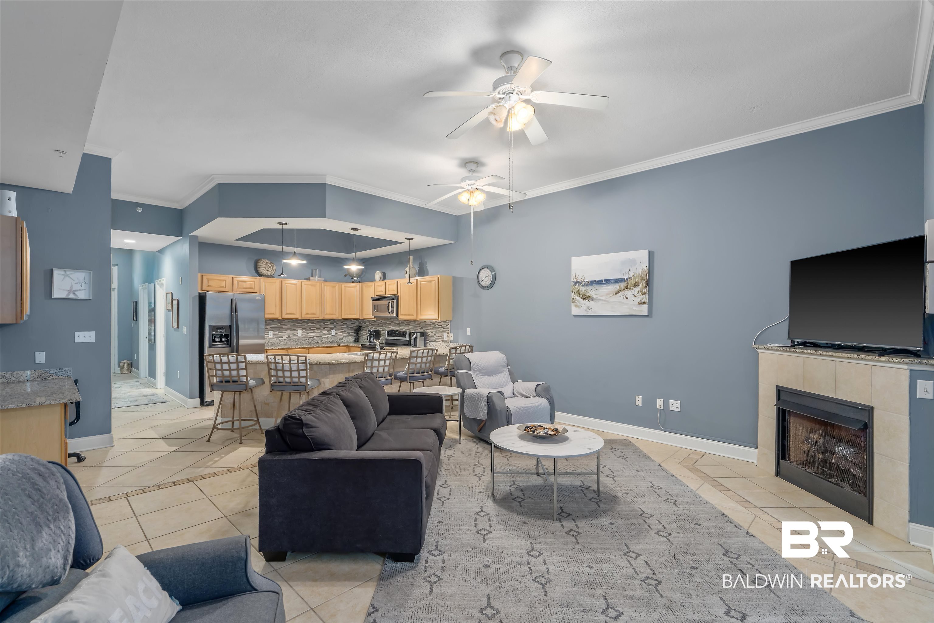 27800 Canal Road, Unit 113 Orange Beach, AL 36561 - Photo 8 of 35 Living area with light tile patterned floors, ornamental molding, a ceiling fan, and a fireplace