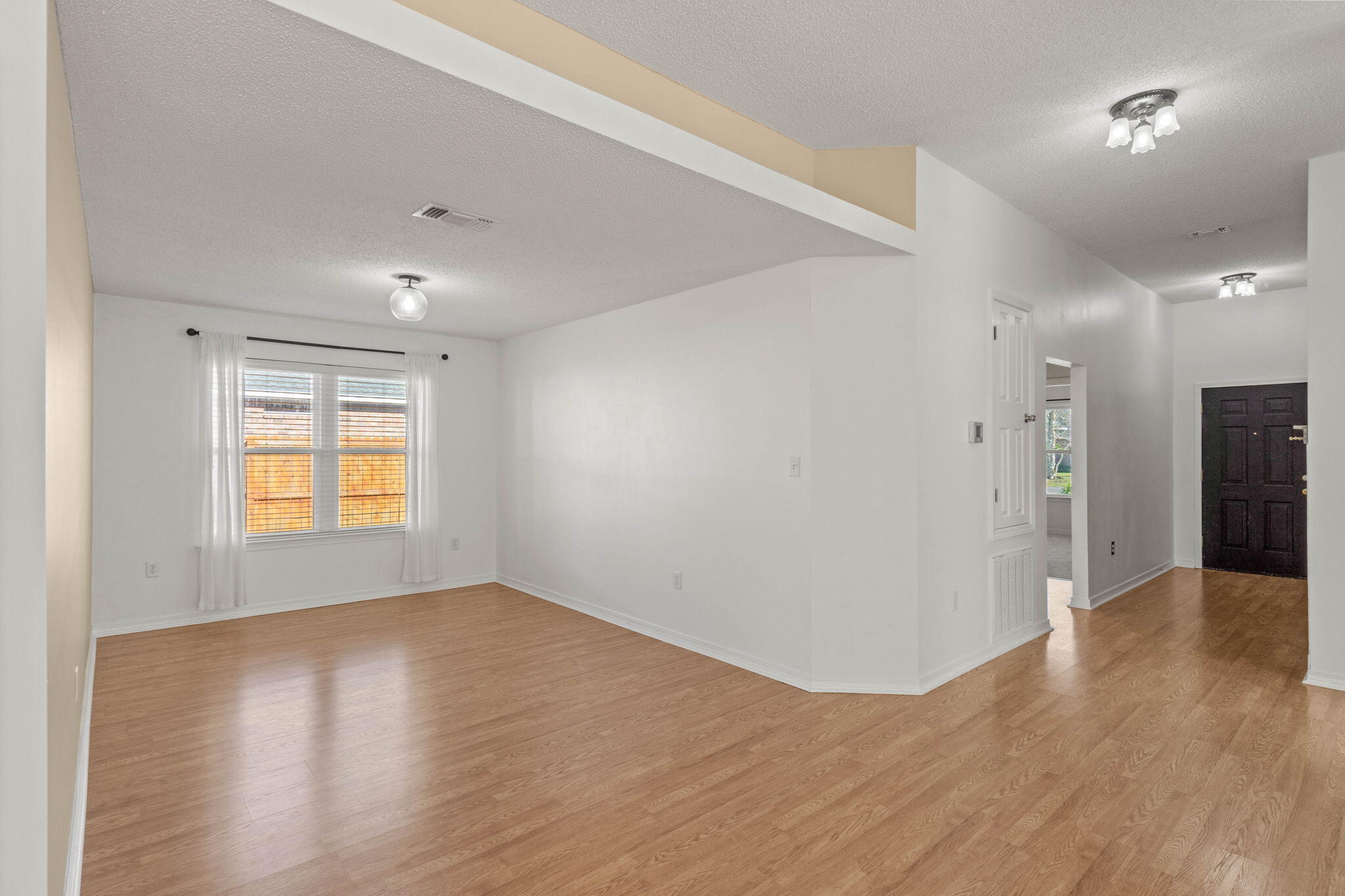 3128 Border Creek Drive Crestview, FL 32539 - Photo 5 of 23 a view of an empty room with wooden floor and a window