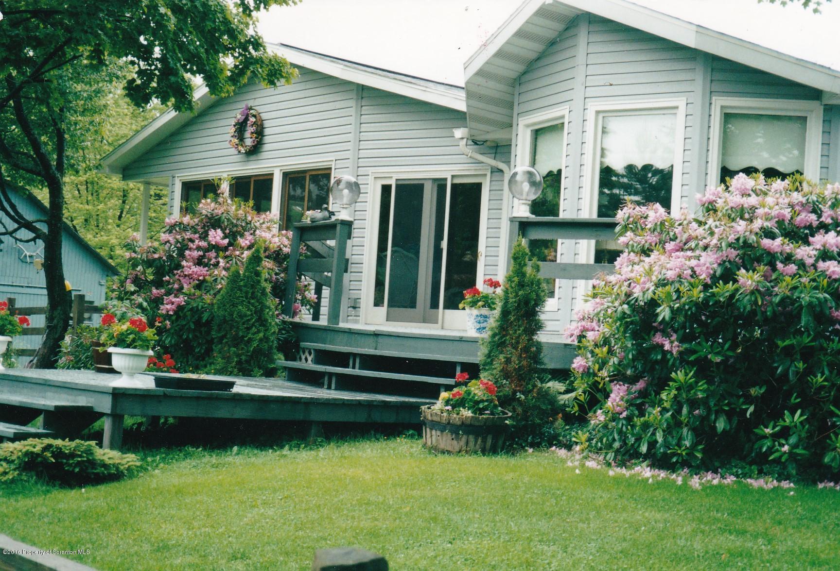 3225 Major Road Moscow, PA 18444 - Photo 1 of 27 a front view of a house with a garden and trees