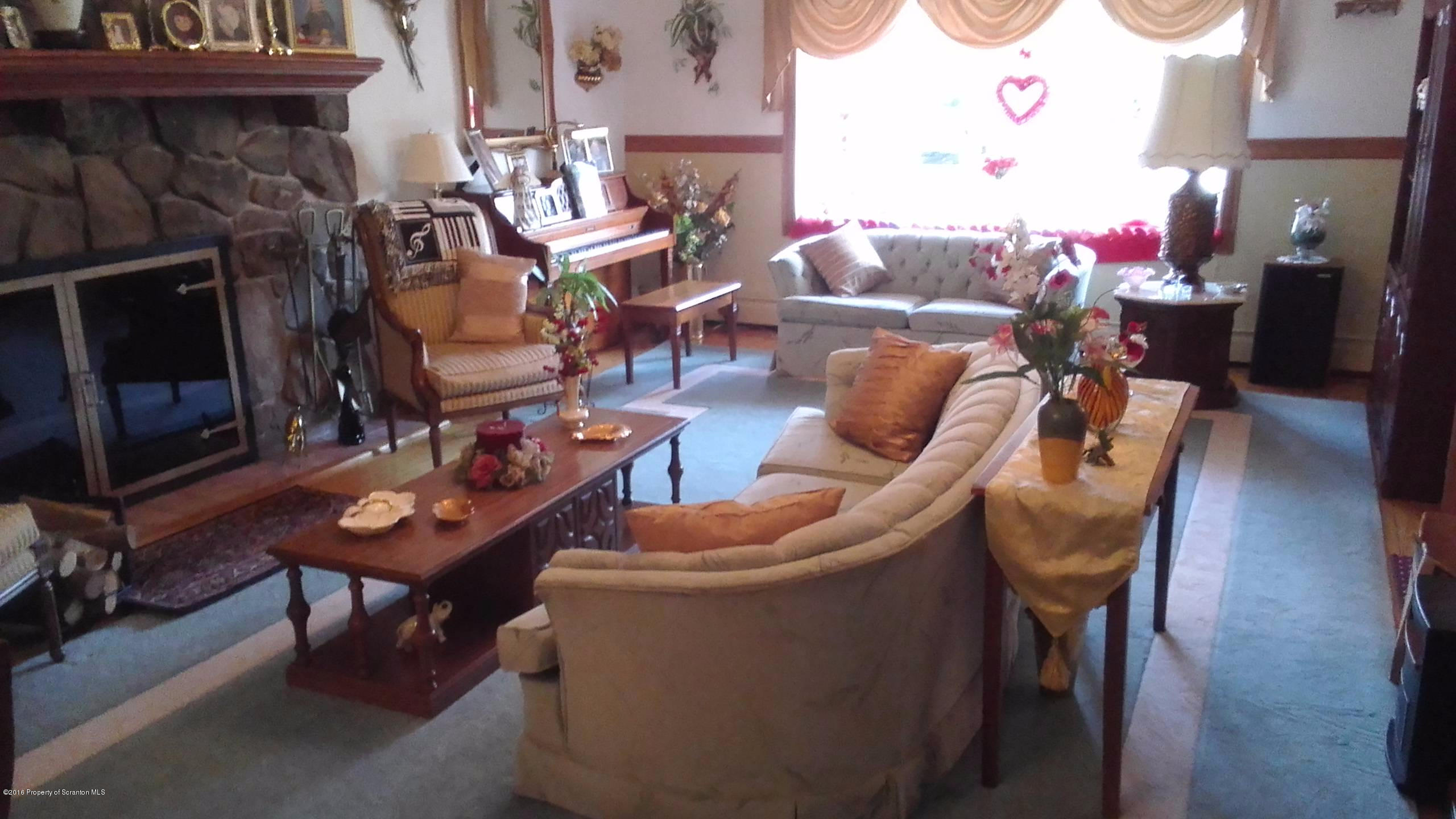 3225 Major Road Moscow, PA 18444 - Photo 6 of 27 a living room with furniture a rug and a fireplace
