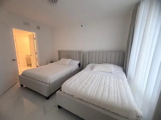 a bedroom with two beds and a window