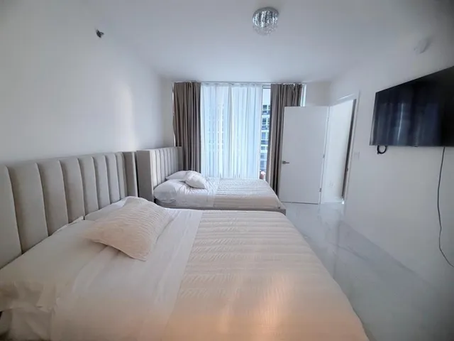 a large white bed in a white room