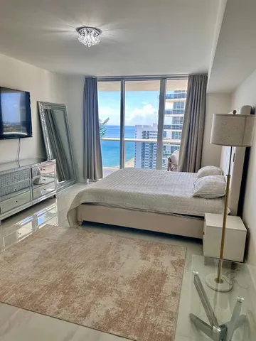 a bedroom with a bed and large mirror