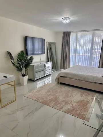 a bedroom with a bed and a potted plant