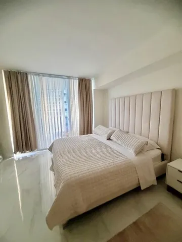 a bed sitting in a bedroom next to a window