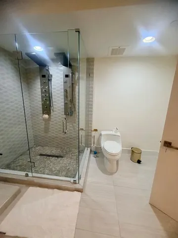 a bathroom with a granite countertop sink a toilet and a shower