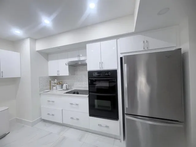 a kitchen with white cabinets and stainless steel appliances