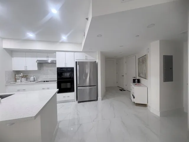 a kitchen with refrigerator and cabinets