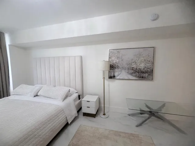 a bedroom with a bed and glass wall