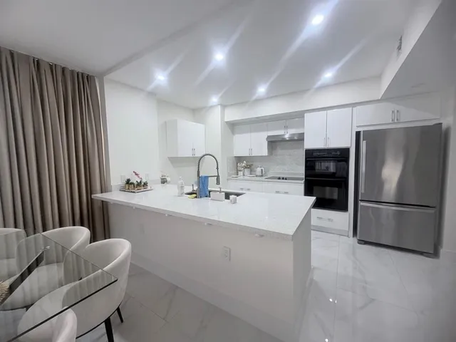 a kitchen with refrigerator and chairs