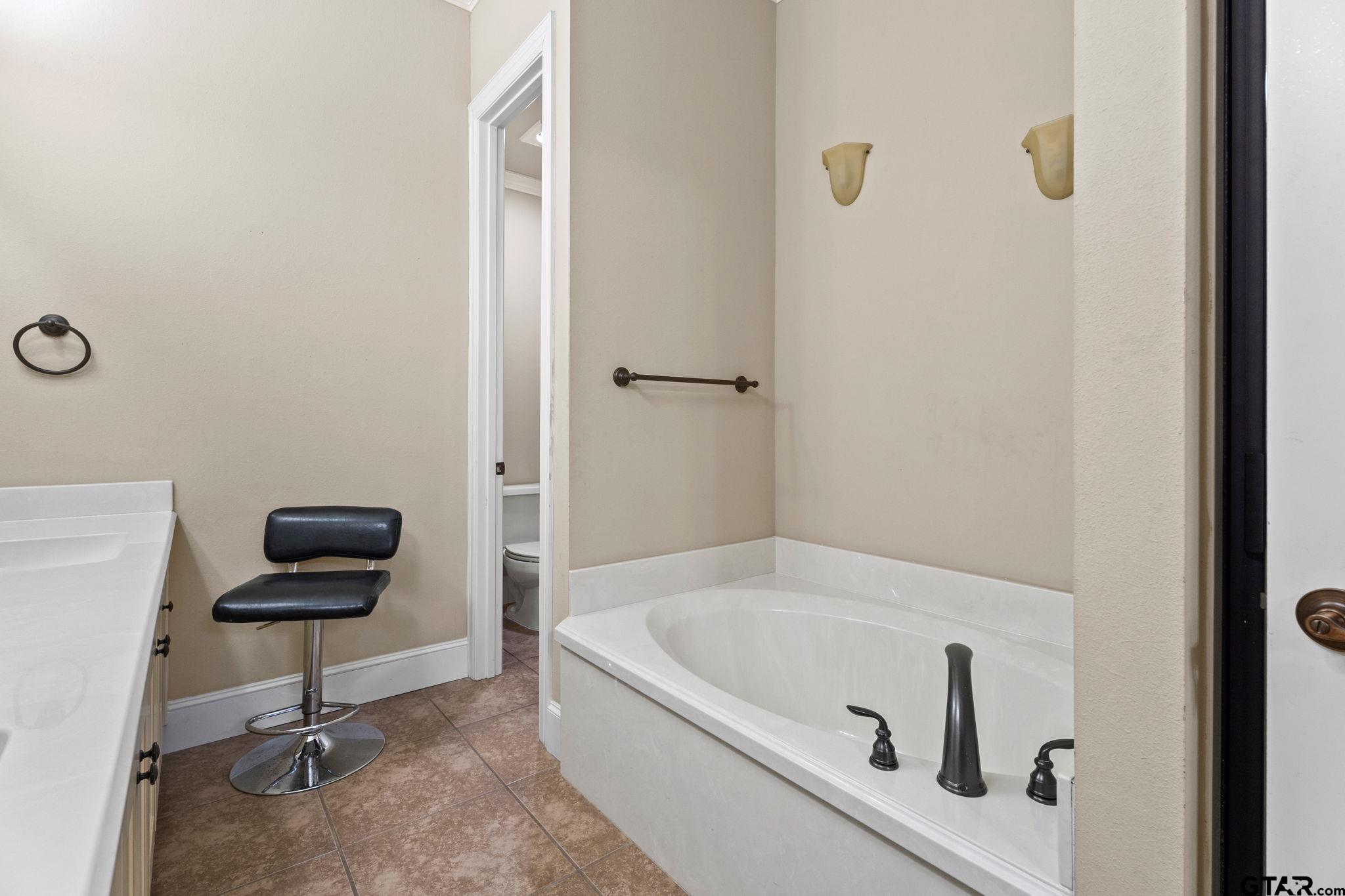 1857 Stonecrest Boulevard, Unit 1302 Tyler, TX 75703 - Photo 15 of 29 a bathroom with a bathtub and a window