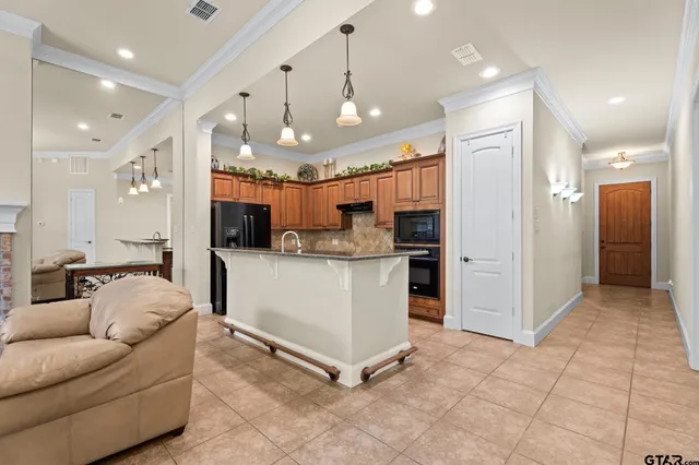 a living room with kitchen furniture and a chandelier