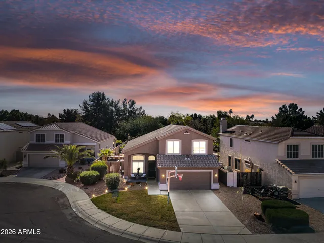 a front view of a house with a garden and mountain view