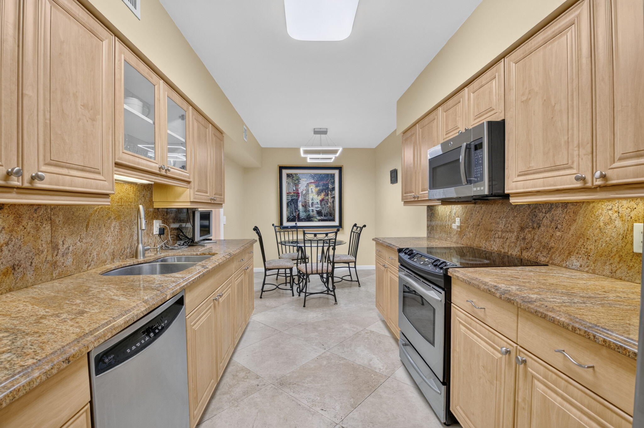 1401 South Ocean Boulevard, Unit 1060 Boca Raton, FL 33432 - Photo 10 of 46 a kitchen with granite countertop a sink and cabinets