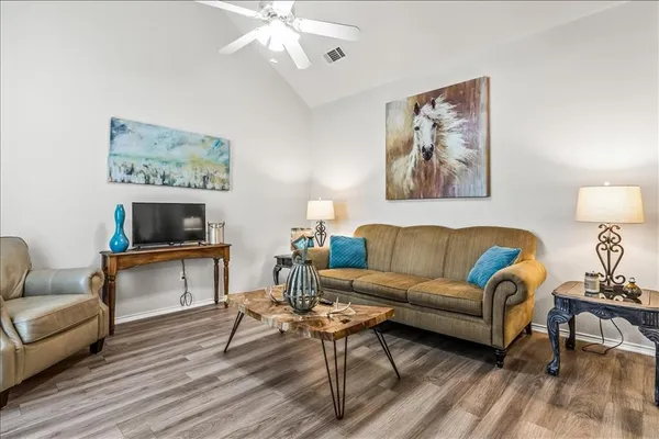 a living room with furniture and a wooden floor