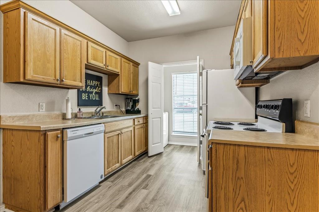 115 Collett Court Weatherford, TX 76088 - Photo 4 of 11 a kitchen with stainless steel appliances granite countertop a stove a sink and a refrigerator