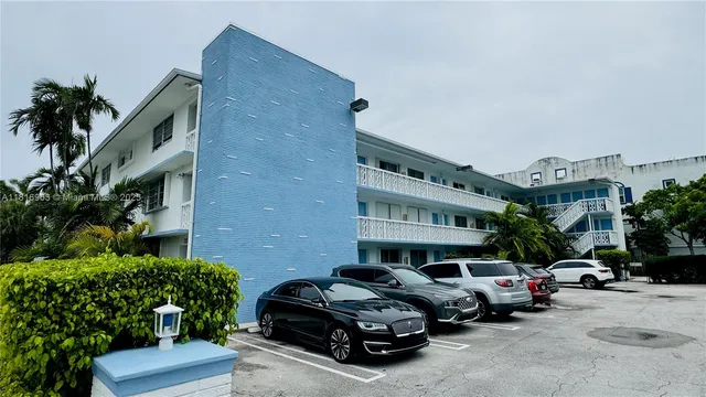 a car parked in front of a brick house with large windows