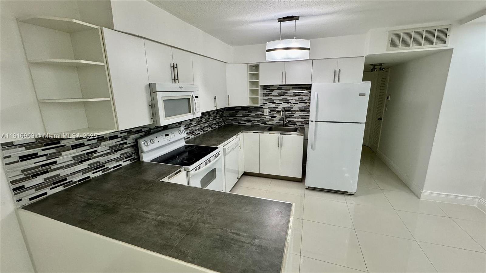 1120 102nd Street, Unit 7 Bay Harbor Islands, FL 33154 - Photo 3 of 22 a kitchen with a sink a stove and refrigerator