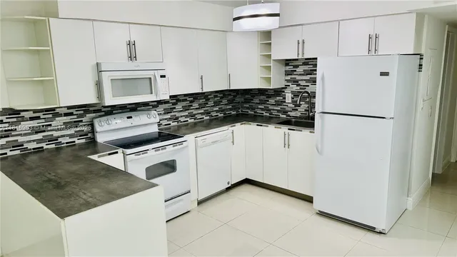 a kitchen with white cabinets and white appliances