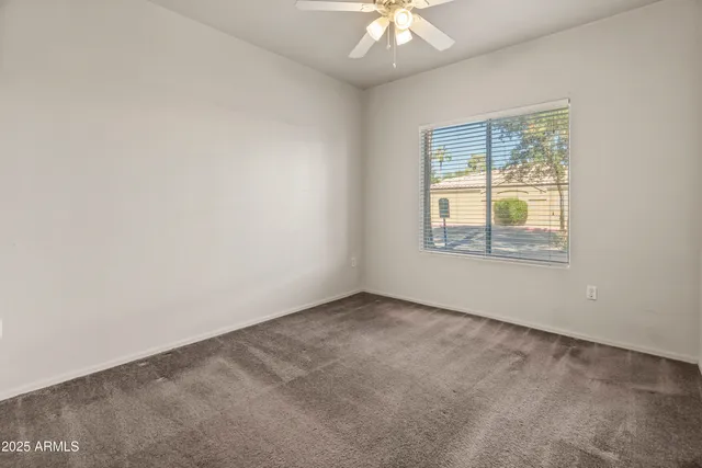 an empty room with a chandelier fan
