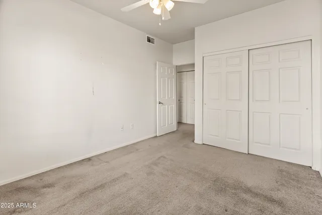 an empty room with a chandelier fan