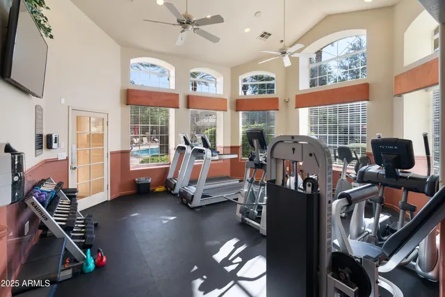 a bedroom with furniture a flat screen tv and a large window