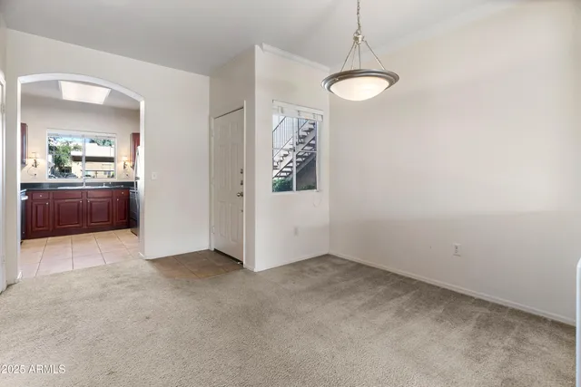 an empty room with chandelier and windows