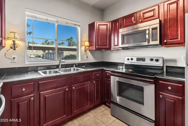a kitchen with stainless steel appliances granite countertop a sink stove and microwave