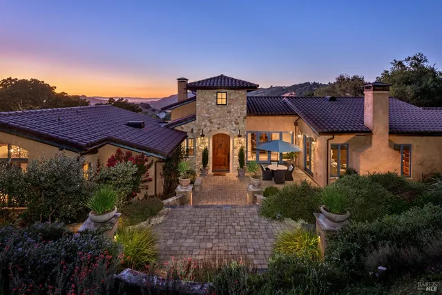 a front view of house with a yard and potted plants