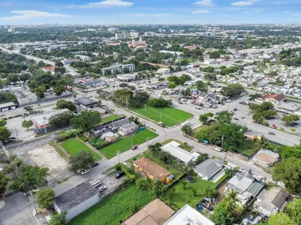 an aerial view of residential houses with outdoor space and trees